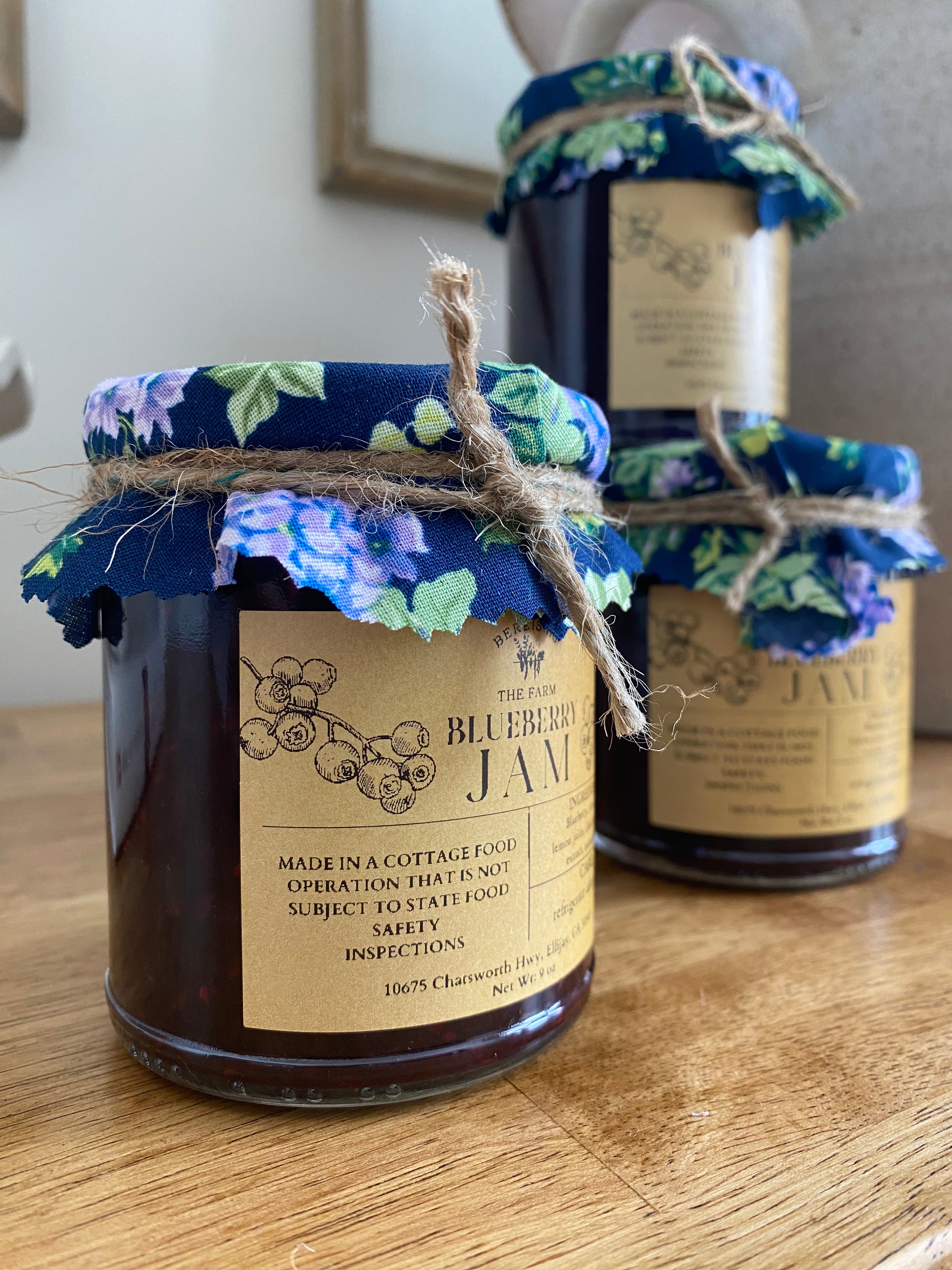 Homemade blueberry jam made with fresh blueberries, raw honey, lemon juice, chia seeds, vanilla extract, and natural pectin, displayed in a charming organic farm store in Ellijay, Georgia 30540, offering a rustic and welcoming atmosphere.