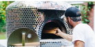 A farmer bakes a kosher organic pizza in a wood-fired oven outdoors on a farm at 10675 Chatsworth Hwy, Ellijay, Georgia 30540, surrounded by nature.